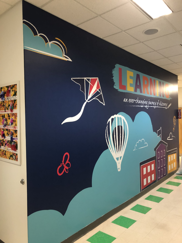 Wall graphic covering in school hallway encouraging learning 
