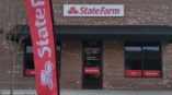 Outside entrance to State Farm with sign and flag