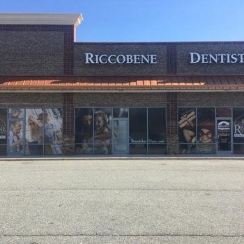 Storefront door and window covered advertisement for Riccobene family dentistry