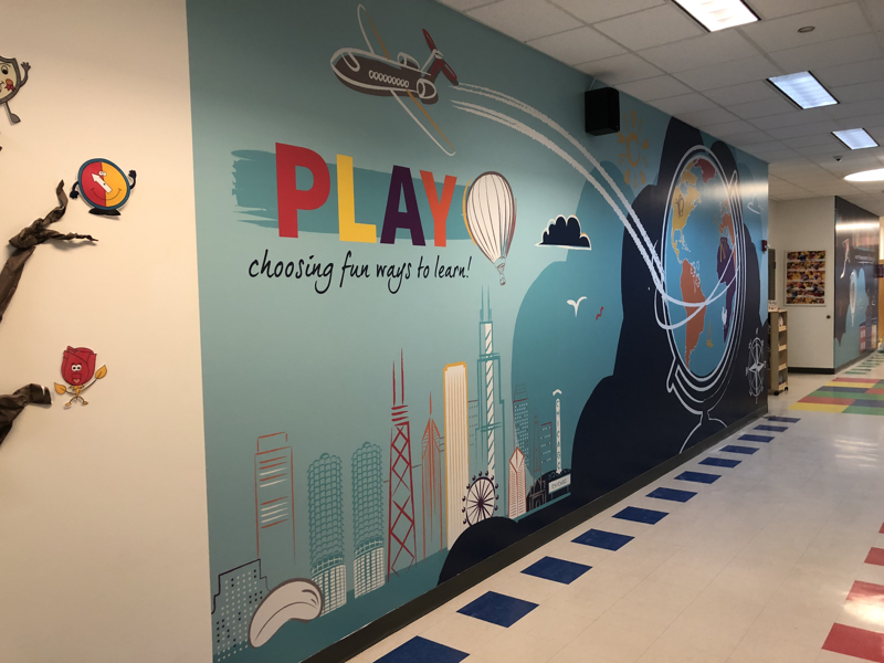 Wall graphic covering in school hallway encouraging play