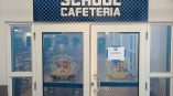 School cafeteria entrance with prominent outdoor signage
