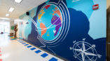 Wall graphic covering in school hallway encouraging play