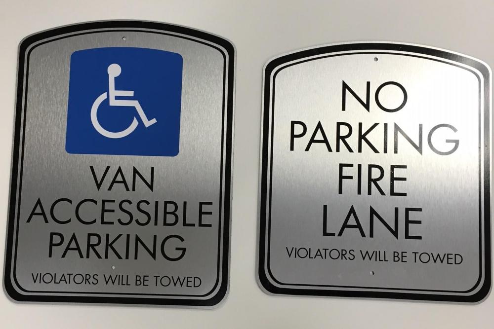 Wall signs for handicap accessible parking and no parking fire lane. 