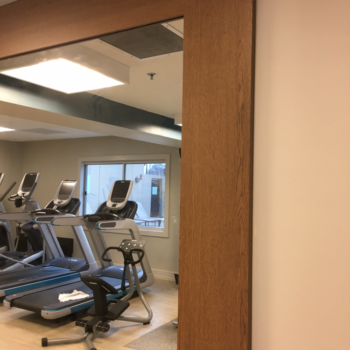 Close-up of mirror with wooden wrap frame in a workout room
