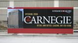 The Carnegie opening date signage on construction fence