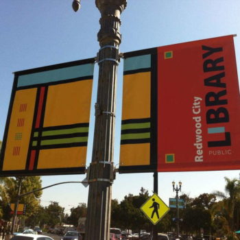 Hanging banners on a lightpost for Redwood City Library