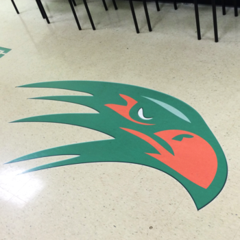 An indoor floor graphic of a green and orange eagle