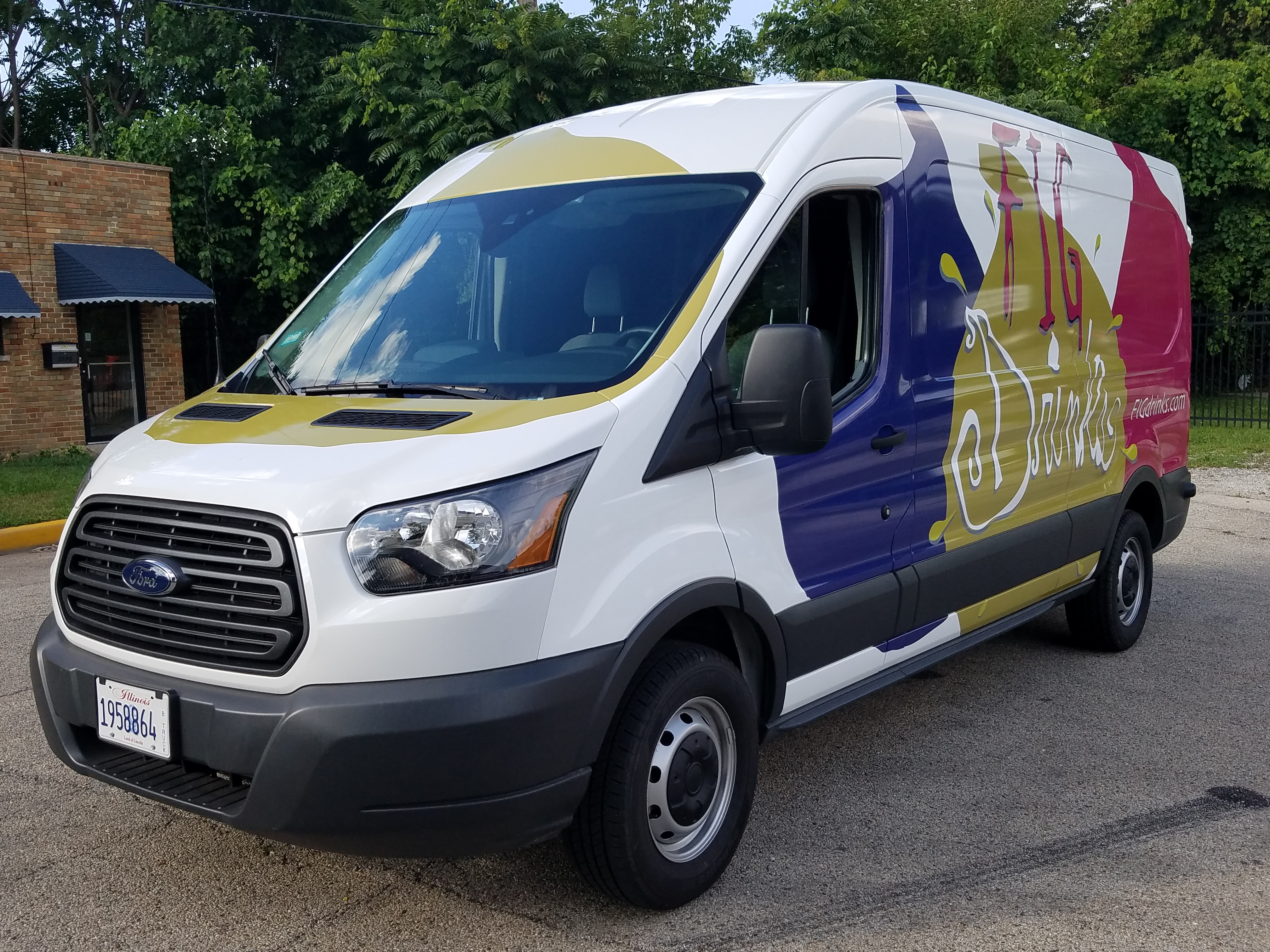 A white van with a vehicle wrap for Fig Drinks