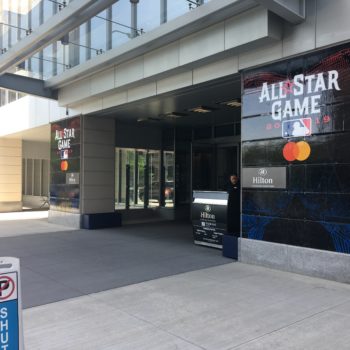 A wall graphic for the MLB All Star Game outside a Hilton Hotel