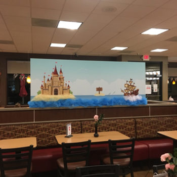 Cartoon pirate ship and sand castle banner for restaurant.
