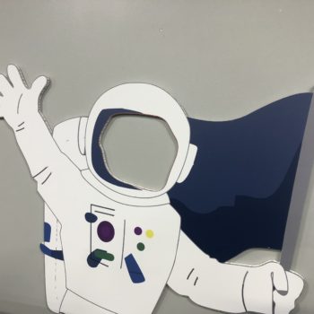 Astronaut holding a flag cardboard cutout. 