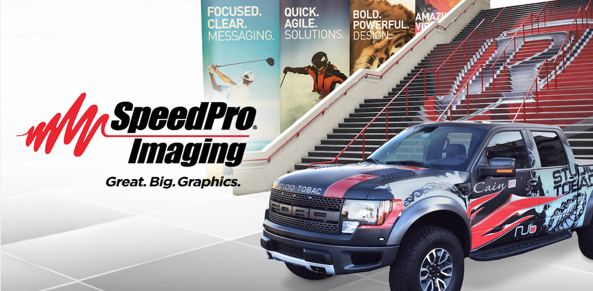 SpeedPro imaging custom banner graphics, custom wrapped truck, and custom floor logo.