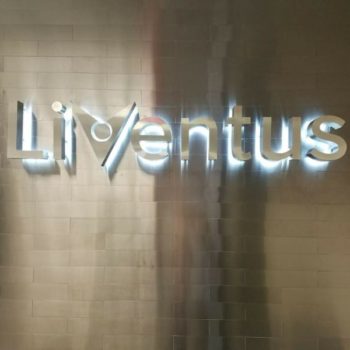 Liventus sign hanging on a wall with backdrop lighting. 
