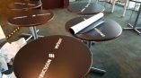 Round vinyl table wraps with logos applied on multiple tables in Chicago Downtown.