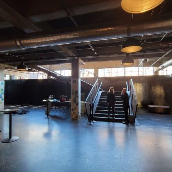 Two pillar wraps with geometric designs and text in an industrial event space in Chicago Downtown.