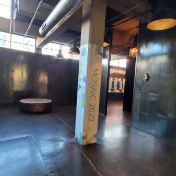 Printed vinyl pillar wrap with geometric patterns and text in an industrial space in Chicago
