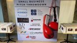 Fabric event backdrop with boxing gloves graphic and sponsor logos in Chicago Downtown.