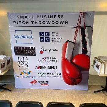 Fabric event backdrop with boxing gloves graphic and sponsor logos in Chicago Downtown.