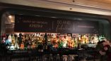 Large fabric banner sign with gold text above a bar counter in Chicago Downtown.