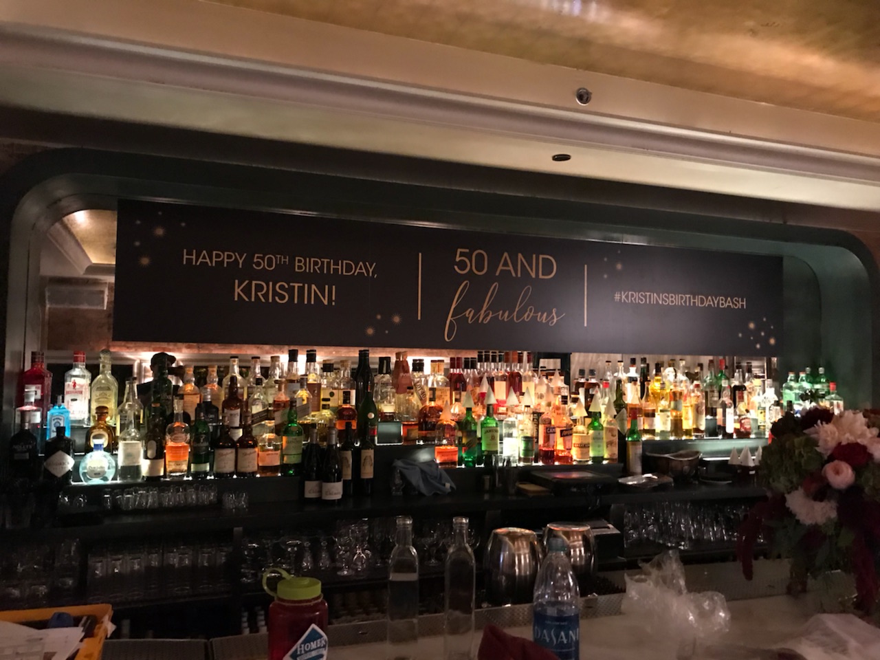 Large fabric banner sign with gold text above a bar counter in Chicago Downtown.