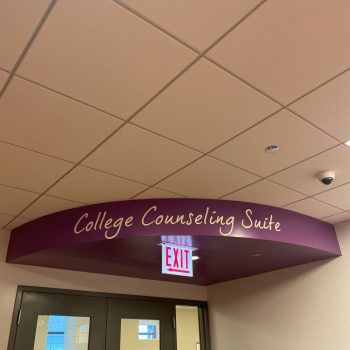 Curved vinyl wall sign above double doors in an indoor hallway in Chicago Downtown.