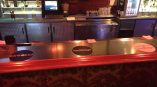 Metal bar counter with circular vinyl decals and diamond plate cabinet doors in Chicago Downtown.