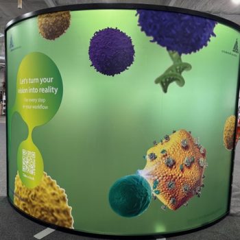 Curved fabric trade show display with vibrant graphics and black frame in Chicago Downtown.