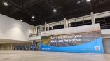 Large indoor fabric banner with printed graphics and text hanging in a convention center in Chicago