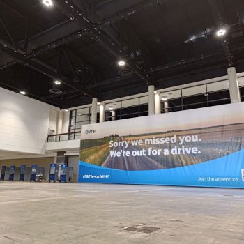 Large indoor fabric banner with printed graphics and text hanging in a convention center in Chicago