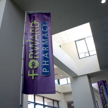 Indoor fabric banner with grommets and pole mount hanging in a building lobby in Chicago Downtown.