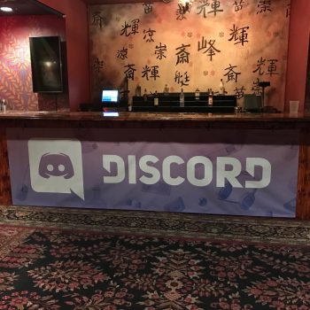 Vinyl banner with logo attached to wooden bar front in indoor venue Chicago Downtown.