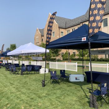 Outdoor feather flags and fabric banners displayed with pop-up tents on grass in Chicago Downtown.