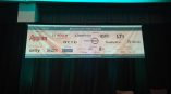 Indoor vinyl event banner with sponsor logos hanging against black curtains in Chicago Downtown.