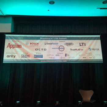 Indoor vinyl event banner with sponsor logos hanging against black curtains in Chicago Downtown.