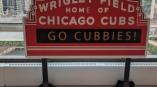 Freestanding event sign shaped like Wrigley Field marquee with printed graphics in Chicago Downtown.