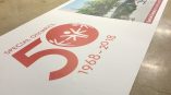 Large vinyl banner with printed graphics and text laid out on a workshop floor in Chicago Downtown.