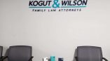 Acrylic wall sign with black and teal letters mounted above chairs in Chicago Downtown office.