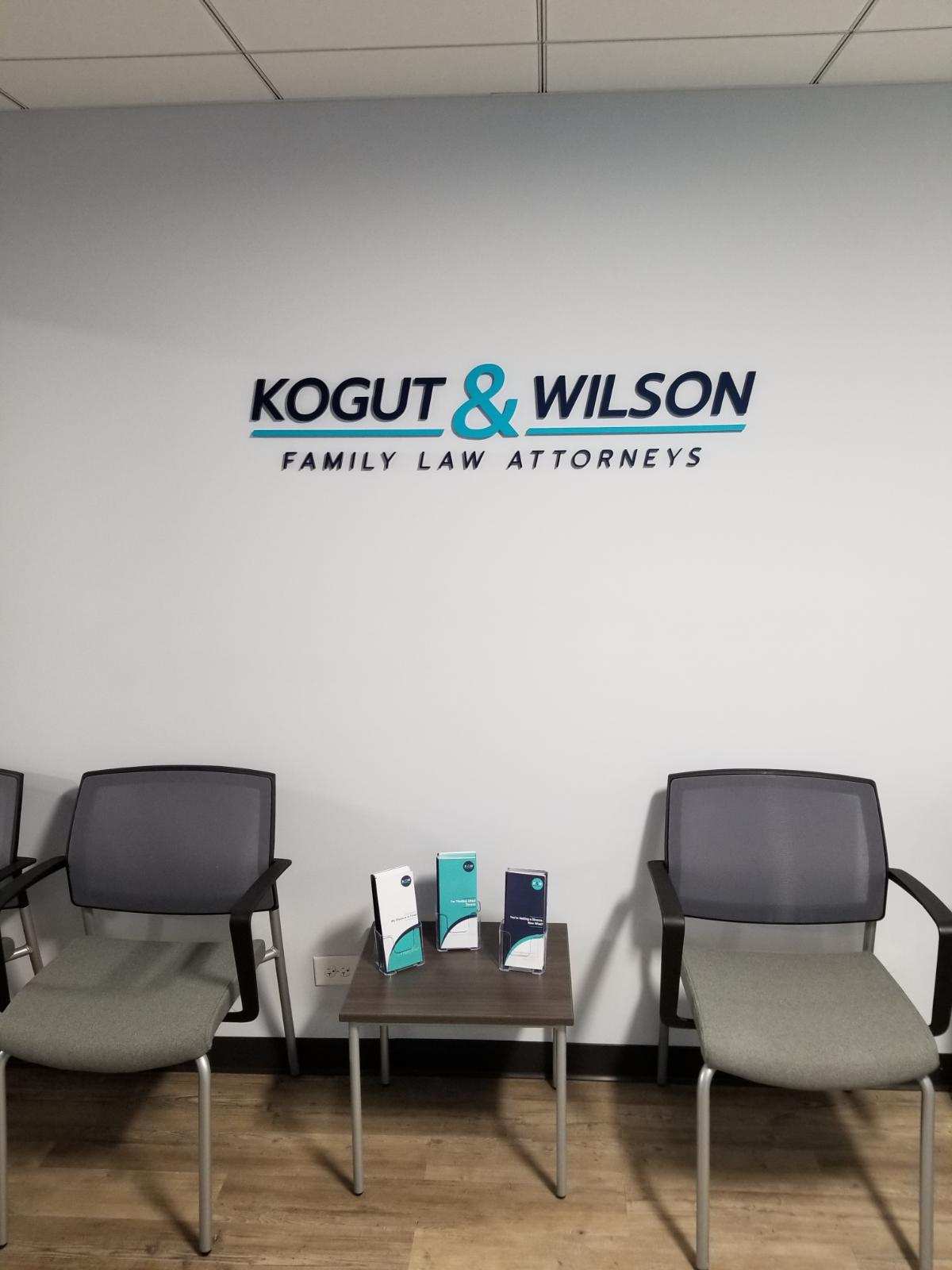 Acrylic wall sign with black and teal letters mounted above chairs in Chicago Downtown office.
