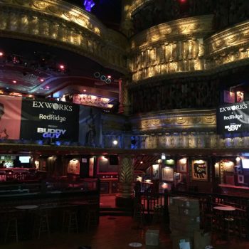 Two large vinyl banners hanging inside an ornate theater with gold trim in Chicago Downtown.