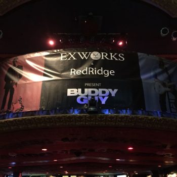 Indoor vinyl banner with grommets hanging on balcony railing in Chicago Downtown.