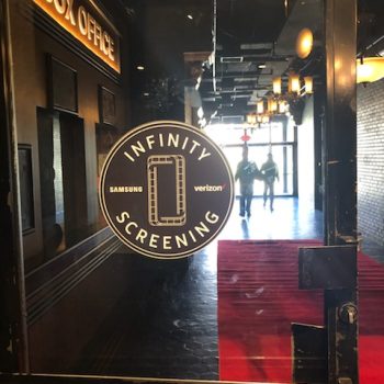 Circular window decal with film reel graphic and text on glass door in Chicago Downtown.