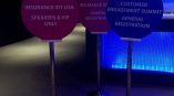 Three round freestanding event signs on metal poles with bases inside a building in Chicago