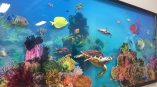 Large acrylic wall sign featuring a colorful underwater coral reef scene with fish and turtle in