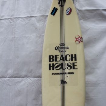 Surfboard with printed vinyl decals and stickers displayed against a white tent in Chicago Downtown.