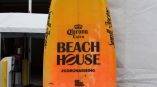 Yellow and orange promotional surfboard sign with vinyl decals displayed in Chicago Downtown.