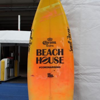 Yellow and orange promotional surfboard sign with vinyl decals displayed in Chicago Downtown.