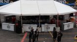 Outdoor event tent with branded vinyl banners and barricade signs in Chicago Downtown.
