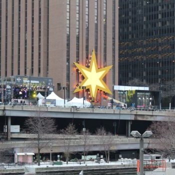 Large illuminated star-shaped event sign mounted on a building in Chicago Downtown.