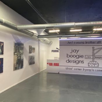 Large fabric event backdrop with printed graphics and mounted photo prints on white wall in Chicago