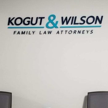 Acrylic wall sign with raised letters in black and teal mounted in Chicago Downtown office.